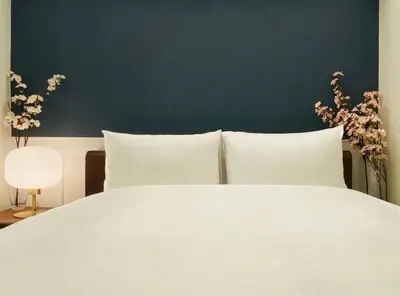 a white bed with white pillows and a blue wall at \u8fd1\u79cb\u53f6\u539f\u4e1c\u4eac\u7ad9 \u8d85\u5962\u534e\u591a\u5367\u5957\u623fKGoa \u5730\u94c12\u5206\u949f 4\u7ad9\u4ea4\u6c47 \u9876\u7ea7\u6234\u68ee\u5439\u98ce \u6700\u59278\u4eba in Tokyo