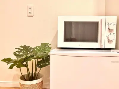 a microwave sitting on top of a refrigerator with a plant at \u8fd1\u79cb\u53f6\u539f\u4e1c\u4eac\u4e2d\u5fc3\u5962\u534e\u5957\u623fKFob \u8f66\u7ad92\u5206 4\u7ad9\u53ef\u7528 \u914d\u5962\u534e\u6234\u68ee \u6700\u59275\u4eba in Tokyo
