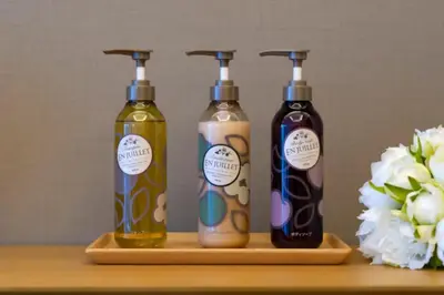 three bottles of soap on a wooden shelf with flowers at \u8fd1\u79cb\u53f6\u539f\u4e1c\u4eac\u4e2d\u5fc3\u8c6a\u534e\u5927\u5e8a\u623fKGob \u8f66\u7ad92\u5206 4\u7ad9\u53ef\u7528 \u914d\u5962\u534e\u6234\u68ee \u9002\u54082\u4eba in Tokyo