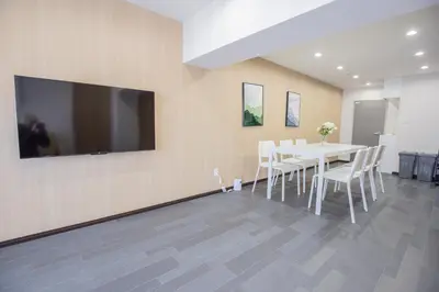 a dining room with a table and a tv on the wall at 1min walk to Higashi Shinjuku sta 8PPL Shinjuku Gyoen\u4e36 National Garden\u4e36 Kabukicho\u4e36 Shinjuku Station\u4e36 Golden Gai\u4e36 Tokyo Metropolitan Government Building YYoQA in Tokyo