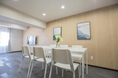 a dining room with a white table and chairs at 1min walk to Higashi Shinjuku sta 8PPL Shinjuku Gyoen\u4e36 National Garden\u4e36 Kabukicho\u4e36 Shinjuku Station\u4e36 Golden Gai\u4e36 Tokyo Metropolitan Government Building YYoQA in Tokyo