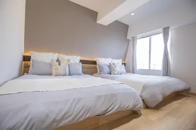 two beds sitting next to each other in a bedroom at 1min walk to Higashi Shinjuku sta 8PPL Shinjuku Gyoen\u4e36 National Garden\u4e36 Kabukicho\u4e36 Shinjuku Station\u4e36 Golden Gai\u4e36 Tokyo Metropolitan Government Building YYoQA in Tokyo