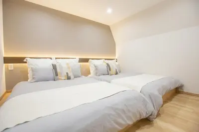 two beds sitting next to each other in a room at 1min walk to Higashi Shinjuku sta 8PPL Shinjuku Gyoen\u4e36 National Garden\u4e36 Kabukicho\u4e36 Shinjuku Station\u4e36 Golden Gai\u4e36 Tokyo Metropolitan Government Building YYoQA in Tokyo