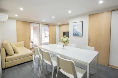 a dining room with a white table and chairs at 1min walk to Higashi Shinjuku sta 8PPL Shinjuku Gyoen\u4e36 National Garden\u4e36 Kabukicho\u4e36 Shinjuku Station\u4e36 Golden Gai\u4e36 Tokyo Metropolitan Government Building YYoQB in Tokyo