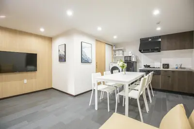 a kitchen and dining room with a white table and chairs at 1min walk to Higashi Shinjuku sta 8PPL Shinjuku Gyoen\u4e36 National Garden\u4e36 Kabukicho\u4e36 Shinjuku Station\u4e36 Golden Gai\u4e36 Tokyo Metropolitan Government Building YYoQB in Tokyo