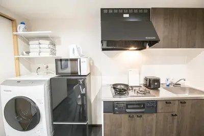 a kitchen with a washing machine and a microwave at 1min walk to Higashi Shinjuku sta 8PPL Shinjuku Gyoen\u4e36 National Garden\u4e36 Kabukicho\u4e36 Shinjuku Station\u4e36 Golden Gai\u4e36 Tokyo Metropolitan Government Building YYoQB in Tokyo