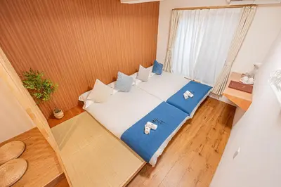 a bedroom with a large bed with blue and white pillows at \u685c\u306e\u5ddd10 \u6c60\u888b\u99c5 7\u5206 2-5\u4eba\u4e28Ikebukuro 7 minutes 2-5 people in Tokyo