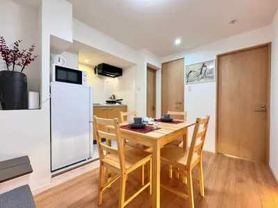 a kitchen with a table and chairs and a refrigerator at Home Stroy in Tokyo-VENTI Okachimachi \u6771\u4eac\u5c4b\u8a9e in Tokyo