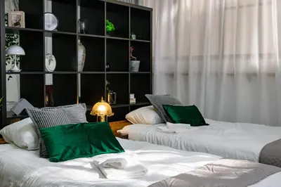 two beds with green pillows in a room at \u6771\u5411\u5cf6\u4e09\u4e01\u76ee\u65c5\u9928 in Tokyo
