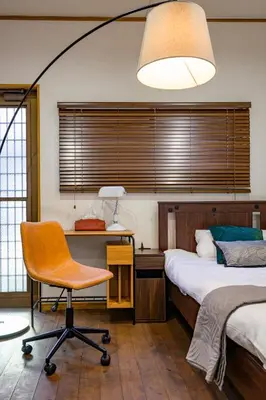 a bedroom with a bed and a desk and a chair at \u6771\u5411\u5cf6\u4e09\u4e01\u76ee\u65c5\u9928 in Tokyo