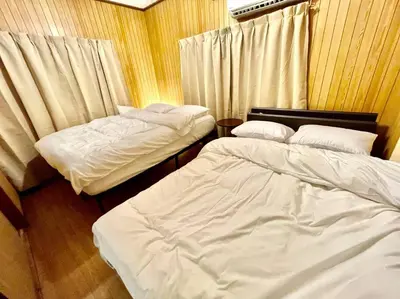 two beds sitting in a room with curtains at \u821e\u6d5c\u306e\u4e00\u8ed2\u5bb6 3\u5bdd\u5ba4 6\u30d9\u30c3\u30c9 \u6771\u4eac\u30c7\u30a3\u30ba\u30cb\u30fc\u30ea\u30be\u30fc\u30c8\u307e\u3067\u8eca5\u5206 \u6771\u4eac\u99c5\u304b\u3089\u597d\u30a2\u30af\u30bb\u30b9 in Urayasu
