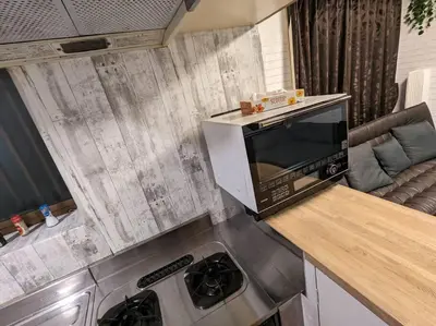a kitchen with a microwave on top of a counter at \u821e\u6d5c\u306e\u4e00\u8ed2\u5bb6 3\u5bdd\u5ba4 6\u30d9\u30c3\u30c9 \u6771\u4eac\u30c7\u30a3\u30ba\u30cb\u30fc\u30ea\u30be\u30fc\u30c8\u307e\u3067\u8eca5\u5206 \u6771\u4eac\u99c5\u304b\u3089\u597d\u30a2\u30af\u30bb\u30b9 in Urayasu