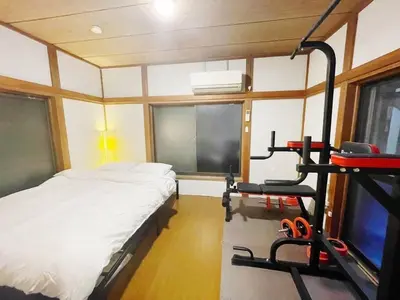 a bedroom with a bed and a treadmill at \u821e\u6d5c\u306e\u4e00\u8ed2\u5bb6 3\u5bdd\u5ba4 6\u30d9\u30c3\u30c9 \u6771\u4eac\u30c7\u30a3\u30ba\u30cb\u30fc\u30ea\u30be\u30fc\u30c8\u307e\u3067\u8eca5\u5206 \u6771\u4eac\u99c5\u304b\u3089\u597d\u30a2\u30af\u30bb\u30b9 in Urayasu