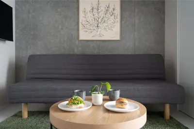 a coffee table with two plates of food on a couch at MINI HOUSE Tokyo South in Tokyo