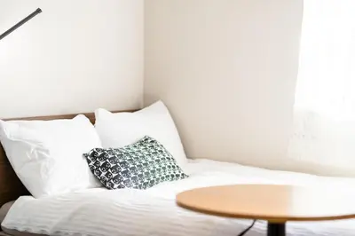 a bed with white pillows and a table at \u76ee\u9ed2\u6075\u6bd4\u5bff\u30a8\u30ea\u30a2 1\u968e One Room Stadio \u76ee\u9ed2\u5ddd\u306b\u8fd1\u3044 in Tokyo