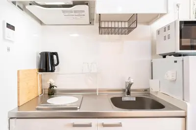 a small kitchen with a sink and a microwave at \u76ee\u9ed2\u6075\u6bd4\u5bff\u30a8\u30ea\u30a2 1\u968e One Room Stadio \u76ee\u9ed2\u5ddd\u306b\u8fd1\u3044 in Tokyo
