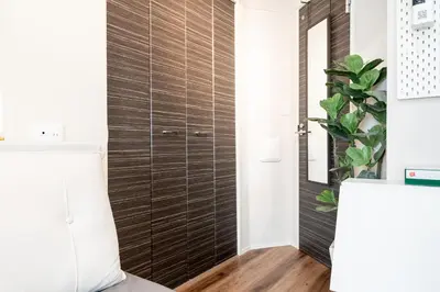 a bathroom with a wooden door in a room at \u76ee\u9ed2\u6075\u6bd4\u5bff\u30a8\u30ea\u30a2 1\u968e One Room Stadio \u76ee\u9ed2\u5ddd\u306b\u8fd1\u3044 in Tokyo