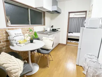 a small kitchen with a table and a white refrigerator at \u6c60\u888b2\u52065\u4eba\u53ef in Tokyo