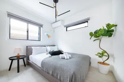 a bedroom with a bed and a potted plant at \u3077\u3075\u304b\u6771\u5411\u5cf6 in Tokyo