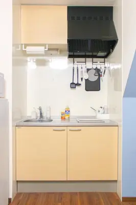 a kitchen with wooden cabinets and a sink at PokaPoka Stay Shinkoiwa R in Tokyo
