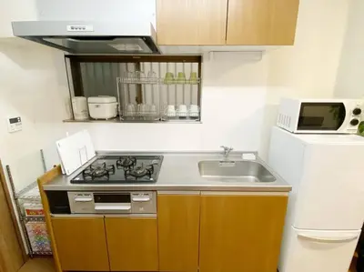 a kitchen with a stove and a sink and a microwave at SunStay Tachiaigawa 2 in Tokyo