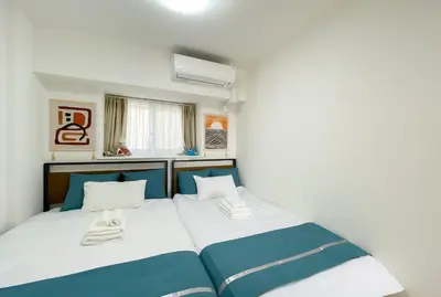 a bedroom with a bed with blue and white sheets at \u5b89\u697d\u9014 in Tokyo