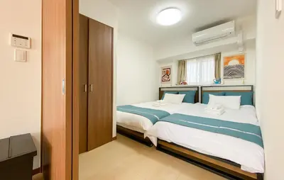 a bedroom with a large bed with blue and white sheets at \u5b89\u697d\u9014 in Tokyo