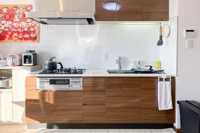 a kitchen with wooden cabinets and a stove top oven at \u5b89\u697d\u9014 in Tokyo
