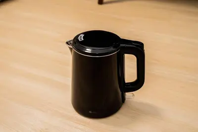 a black coffee pot sitting on a wooden table at \u65b0\u5bbf\u4e2d\u5fc3\u5730\u6b4c\u821e\u4f0e\u753a\u7d27\u90bb\u4f0a\u52bf\u4e39\u7535\u5668\u57ce\u514d\u8d39Wi-Fi\u3002 in Tokyo