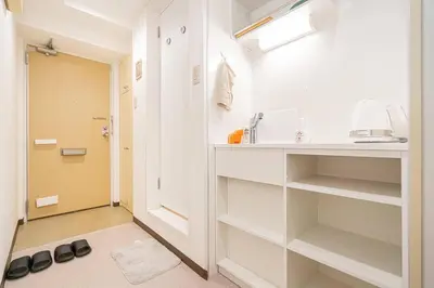 a bathroom with white shelves and a sink and a door at \u65b0\u5bbf\u4e2d\u5fc3\u5730\u6b4c\u821e\u4f0e\u753a\u7d27\u90bb\u4f0a\u52bf\u4e39\u7535\u5668\u57ce\u514d\u8d39Wi-Fi\u3002 in Tokyo