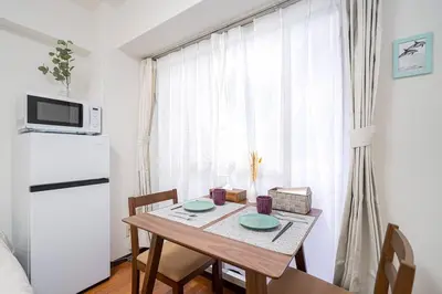 a dining room table with two plates on it at \u65b0\u5bbf\u4e2d\u5fc3\u5730\u6b4c\u821e\u4f0e\u753a\u7d27\u90bb\u4f0a\u52bf\u4e39\u7535\u5668\u57ce\u514d\u8d39Wi-Fi\u3002 in Tokyo