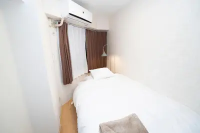 a bedroom with a white bed and a window at \u82b1\u5bbf\u65b0\u5bbf HANAYADO SHINJUKU in Tokyo