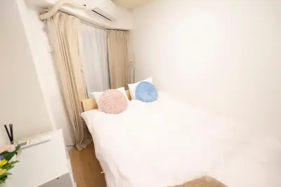 a bedroom with a bed with two pillows on it at \u82b1\u5bbf\u65b0\u5bbf HANAYADO SHINJUKU in Tokyo