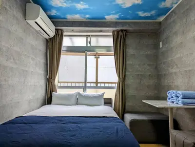 a bedroom with a blue bed and a window at Home cruise\u897f\u5c0f\u5c71 in Tokyo