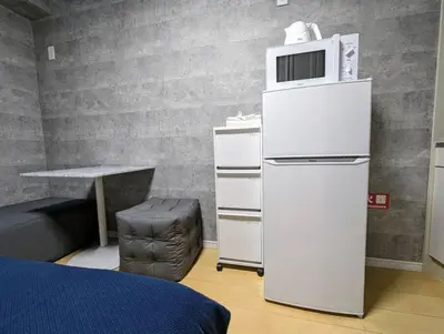 a white refrigerator with a microwave on top of it at Home cruise\u897f\u5c0f\u5c71 in Tokyo
