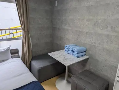 a room with a bed and a table with towels at Home cruise\u897f\u5c0f\u5c71 in Tokyo