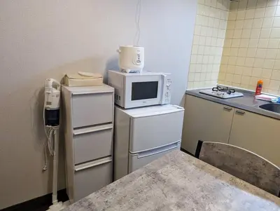 a small kitchen with a microwave on top of a refrigerator at Home cruise\u843d\u5408\u5357\u9577\u5d0e in Tokyo