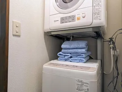 a washing machine and a pile of towels in a bathroom at Home cruise\u843d\u5408\u5357\u9577\u5d0e in Tokyo