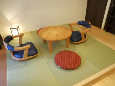 a room with three chairs and a table and a rug at HOTEL BRILLIO ASAKUSABASHI in Tokyo