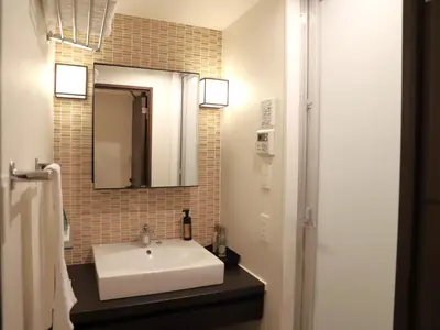 a bathroom with a white sink and a mirror at HOTEL BRILLIO ASAKUSABASHI in Tokyo