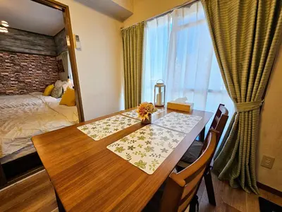 a room with a wooden table and a bedroom at 603 Koiwa Disneyland Airport direct bus in Tokyo