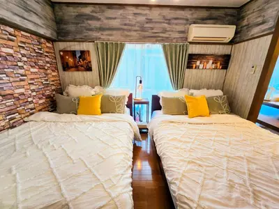 two beds in a room with a brick wall at 603 Koiwa Disneyland Airport direct bus in Tokyo
