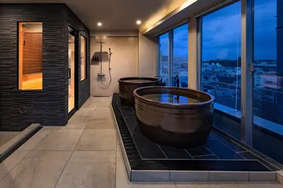 a bathroom with two tubs and a window at The SAUNA Escape Shibuya in Tokyo