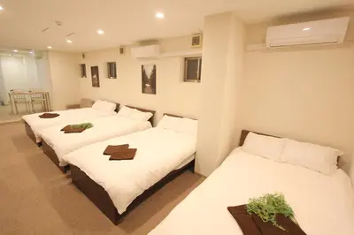 two beds in a room with white sheets at LUANAHOTEL IN KOUENJI in Tokyo