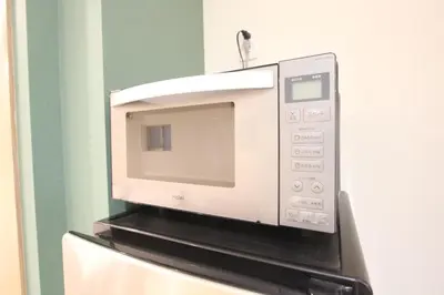a microwave oven sitting on top of a refrigerator at LUANAHOTEL IN KOUENJI in Tokyo