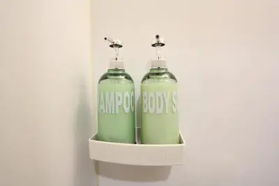 two green bottles sitting on a shelf in a wall at LUANAHOTEL IN KOUENJI in Tokyo