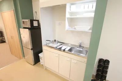 a small kitchen with a sink and a refrigerator at LUANAHOTEL IN KOUENJI in Tokyo