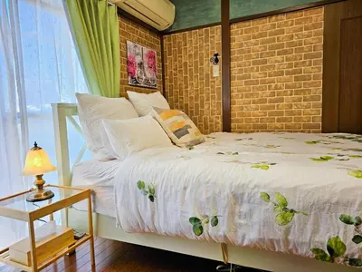 a bedroom with a bed and a brick wall at 703. Disneyland, direct bus to the airport/1minute's walk from the station. in Tokyo