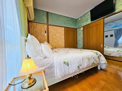 a bedroom with a bed and a television and a lamp at 703. Disneyland, direct bus to the airport/1minute's walk from the station. in Tokyo