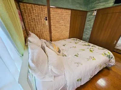 a bed with white sheets and pillows in a room at 703. Disneyland, direct bus to the airport/1minute's walk from the station. in Tokyo